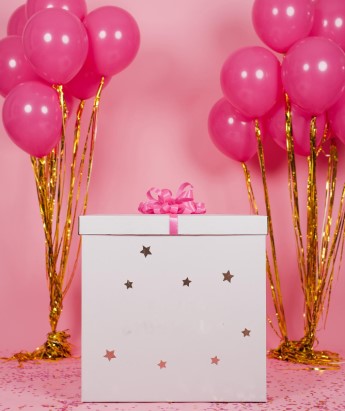 box prezentowy z kokardom i po bokach zestawy balonów różowych napompowane helem
