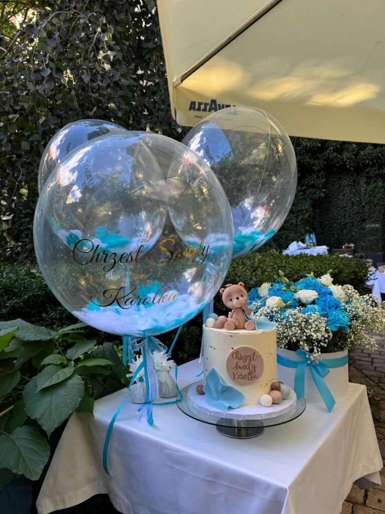 trzy balony przezroczyste ze złotym napisem oraz piórkami biało-turkusowymi w środku