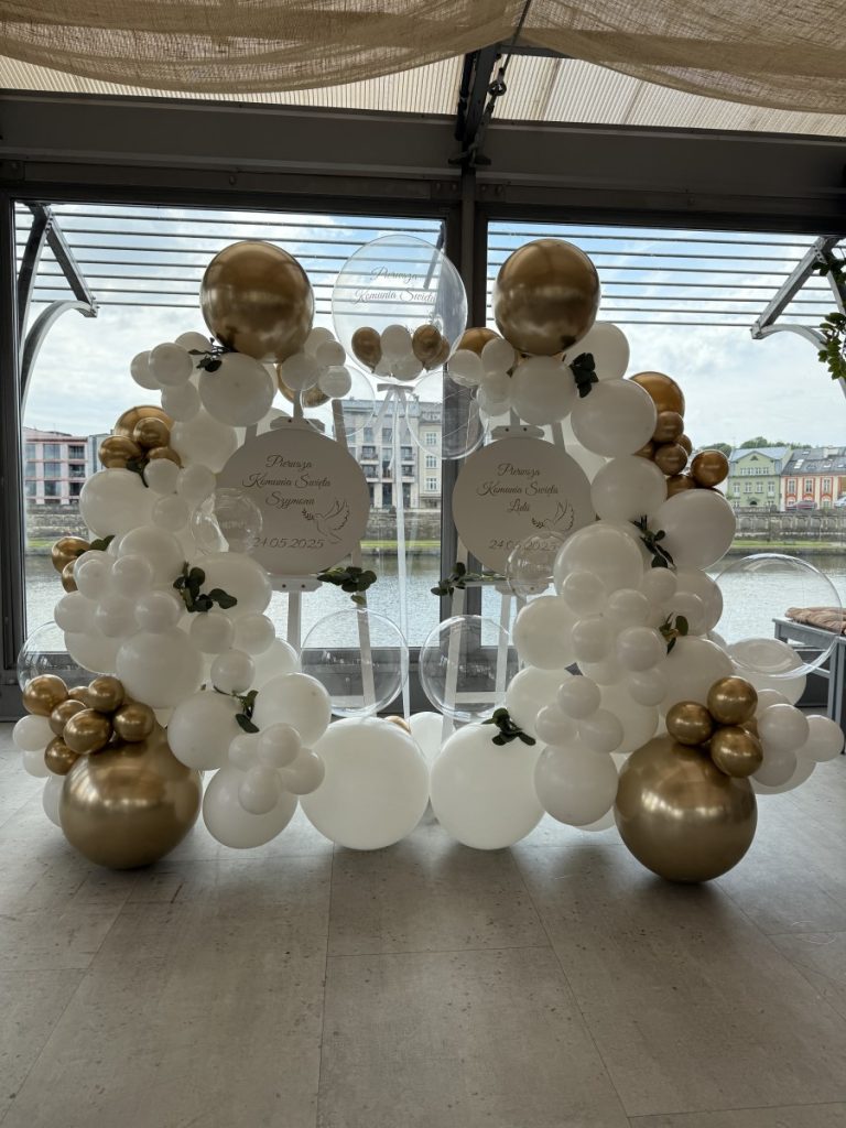 dwie sztalugi połączone z tablicami oraz girlandą balonową na chrzest święty