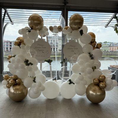 dwie sztalugi połączone z tablicami oraz girlandą balonową na chrzest święty